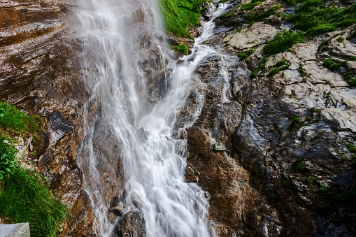 gorgeous high waterfall over a cliff in the mountains detail view