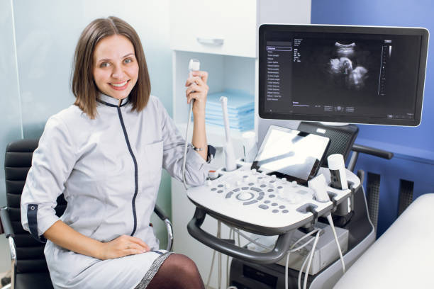istock High-skilled professional attractive woman doctor sonographer using ultrasound machine at work, smiling and looking at camera 1299088661