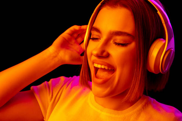 istock Caucasian woman's portrait isolated on black studio background in multicolored neon light 1299090697