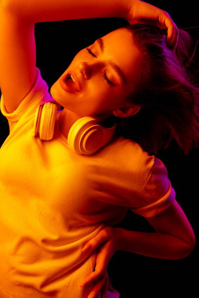 istock Caucasian woman's portrait isolated on black studio background in multicolored neon light 1299090749