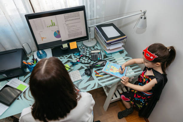 istock Woman teleworking with her daughter drawing 1299094261