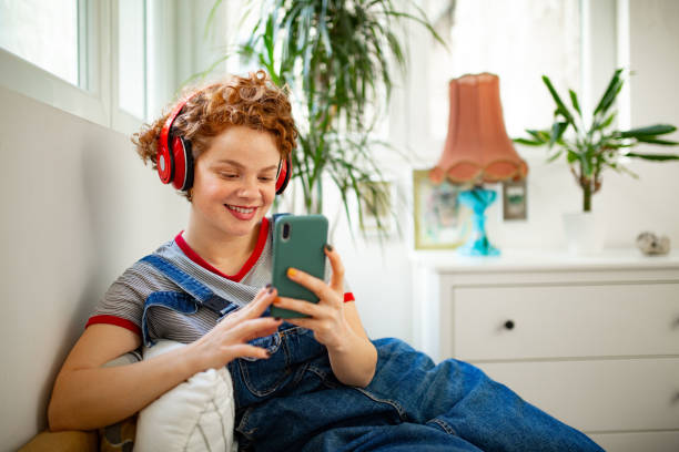 istock Happy Caucasian redhead woman using a smart phone at home 1299096178