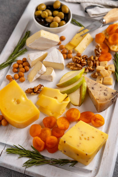 surtido de quesos con frutos secos, peras, albaricoques secos y romero. - cheese still life tray french cuisine fotografías e imágenes de stock