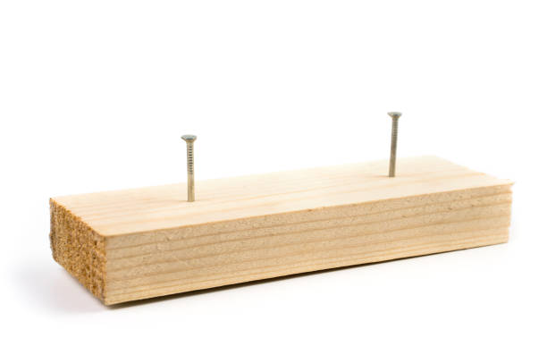 Wooden rail with nails not completely driven in. Demonstration of construction materials, trading platform. The concept of the construction.