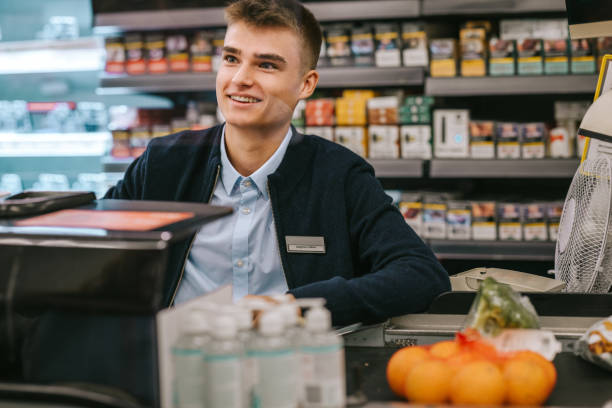 istock Man working at a supermarket checkout counter 1299097850