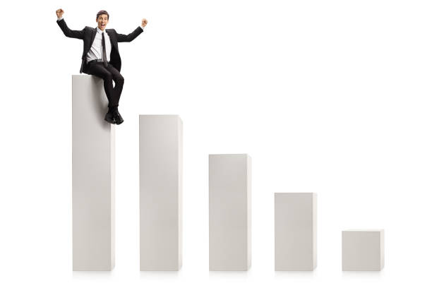 istock Businessman gesturing win and sitting on the highest column in a chart graph 1299098630