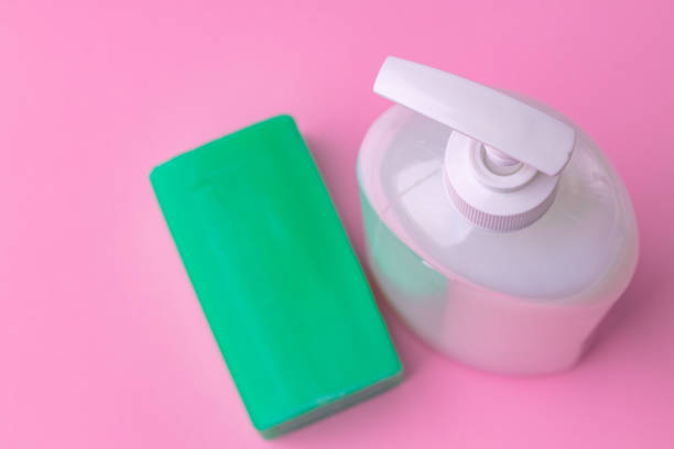 istock Hand antiseptic disinfection, soap bar on pink paper background. 1299098757