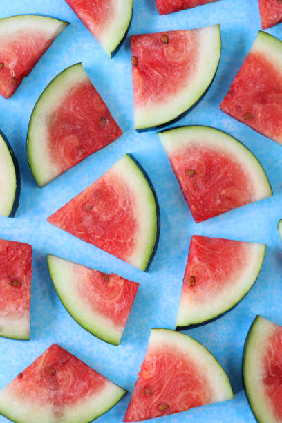 istock Full frame image of watermelon slices / chunks, cut into triangles, blue background, elevated view 1299100488