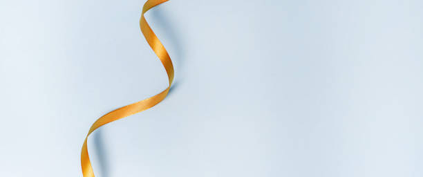 istock Gold ribbon on a blue background. holiday layout . Decorative ornament. Copy space . The preparation of the article. 1299101010