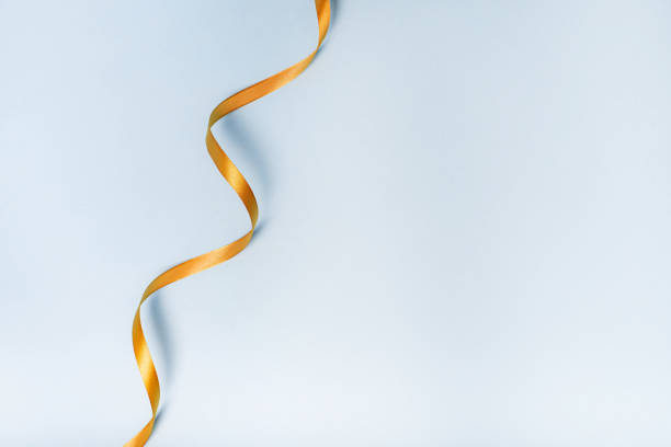 istock Gold ribbon on a blue background. holiday layout . Decorative ornament. Copy space . The preparation of the article. 1299101092
