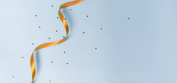 istock Gold ribbon on a blue background. holiday layout . Decorative ornament. Copy space . The preparation of the article. 1299101094