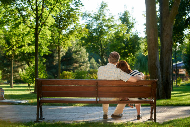istock Back view mature couple on the park bench. 1299103188