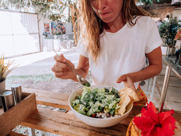 istock Woman eats fresh salad bowl in cafe 1299103297