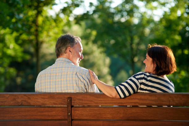 istock Back view happy mature couple on the bench. 1299103523