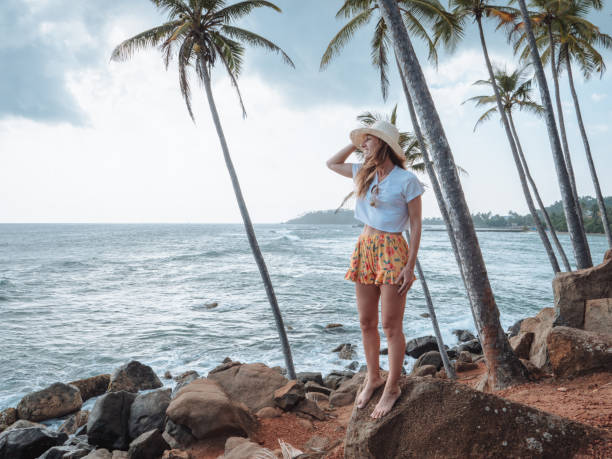 istock Woman contemplates the seascape from rock 1299103727