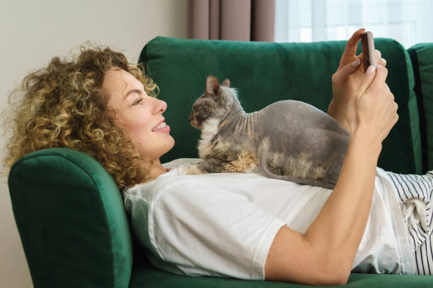 istock Young woman and her cute cat lying  on the sofa 1299103730