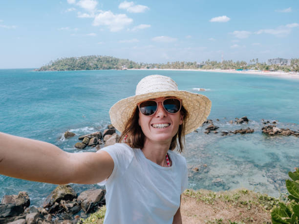 istock Woman takes selfie with seascape 1299104420
