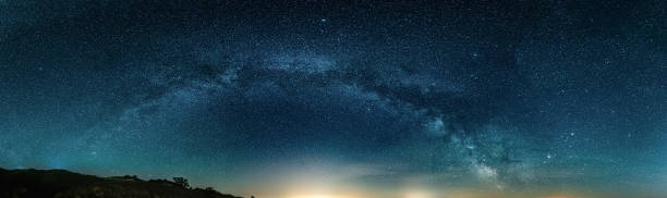 istock Amazing Panoramic Landscape view of Milky way over Night sky 1299104426
