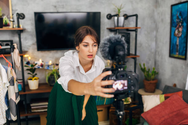 istock Focused female vlogger adjust her camera so she can start to record a fashion vlog 1299104871