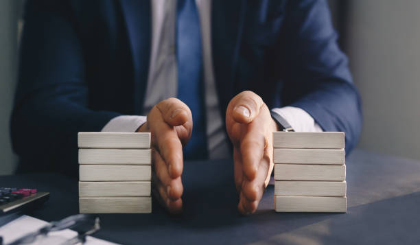 l’homme d’affaires sépare le bloc en bois. concept d’égalité des richesses. division des biens. services de divorce et de droit. - séparation photos et images de collection