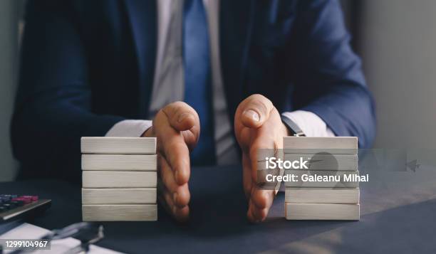 Businessman Separates Wooden Block Concept Of Wealth Equality Division Of Property Divorce And Legal Services Stock Photo - Download Image Now