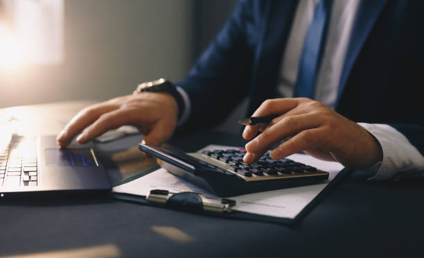 istock Businessman calculating dollars and taking notes. Accounting and taxes. 1299104985