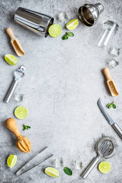 istock Bartender equipment and cocktail ingredietns - shaker, lime and ice. Overhead view 1299105086