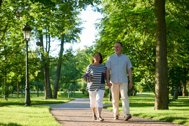 istock Happy smiling mature couple walks in the park. 1299105324