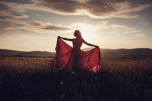 istock beautiful woman walking on wheat field before sunset 1299107056