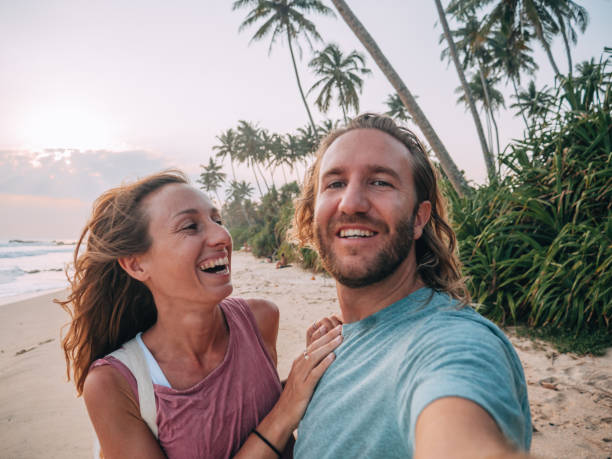 istock Happy couple takes selfie on beach at sunset 1299107060