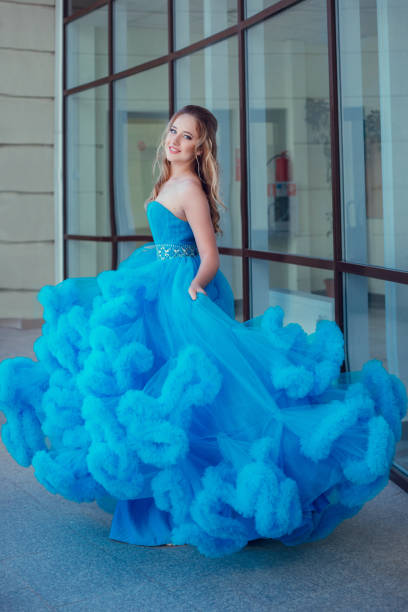 istock Beautiful model in a blue dress over neutral background 1299108455