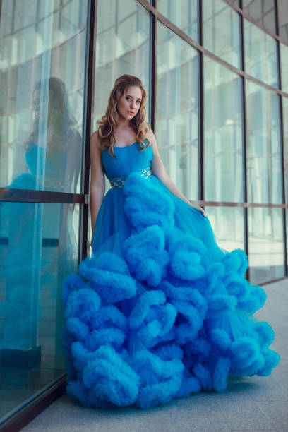 istock Beautiful model in a blue dress over neutral background 1299108475