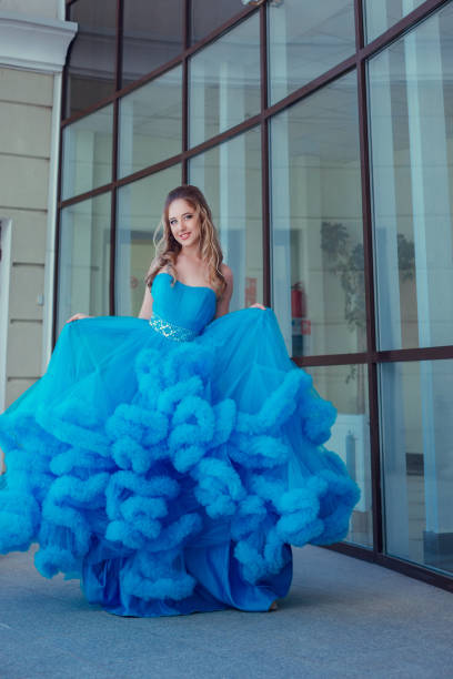 istock Beautiful model in a blue dress over neutral background 1299108612