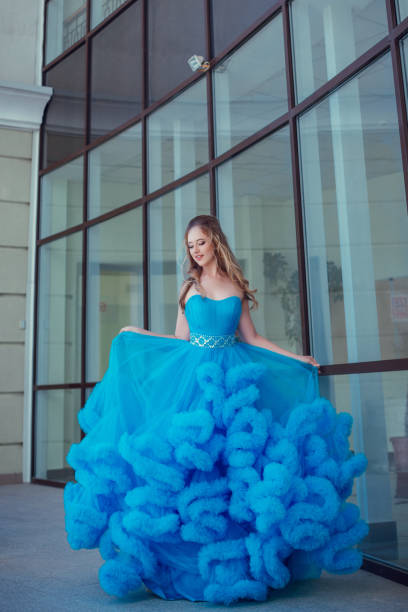 istock Beautiful model in a blue dress over neutral background 1299108675