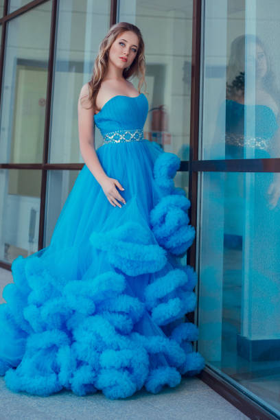 istock Beautiful model in a blue dress over neutral background 1299108678