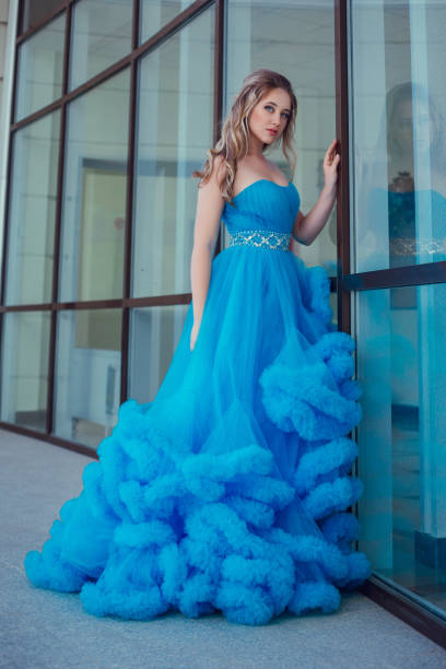 istock Beautiful model in a blue dress over neutral background 1299108776