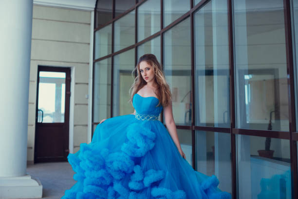 istock Beautiful model in a blue dress over neutral background 1299108849