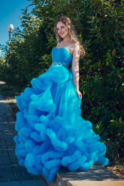 Beautiful model in a blue dress over neutral background
