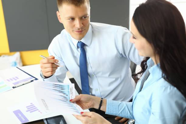 istock Businessman explaining schedules to woman intern in office 1299109731