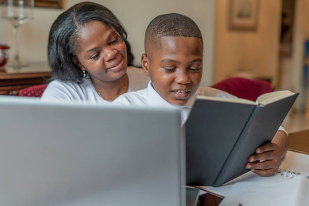 istock Afro mom and son do their homework from their dining room using their laptop to do homework 1299109858