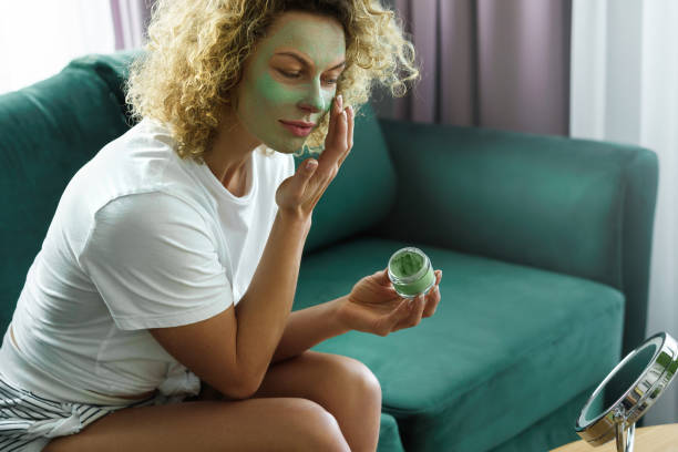 istock Beautiful woman is applying exfoliating and  cleansing mask 1299111254