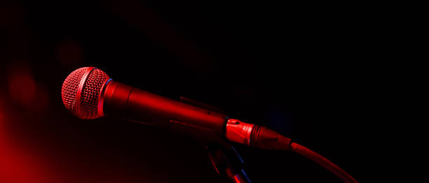 istock Microphone on abstract blurred of speech in seminar room or speaking conference hall light 1299114004