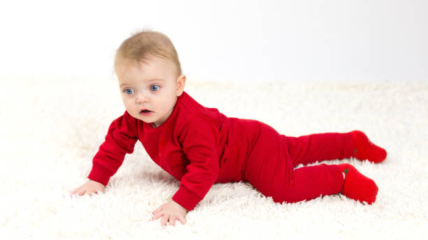 istock Small child in red clothes crawls on the floor 1299114987