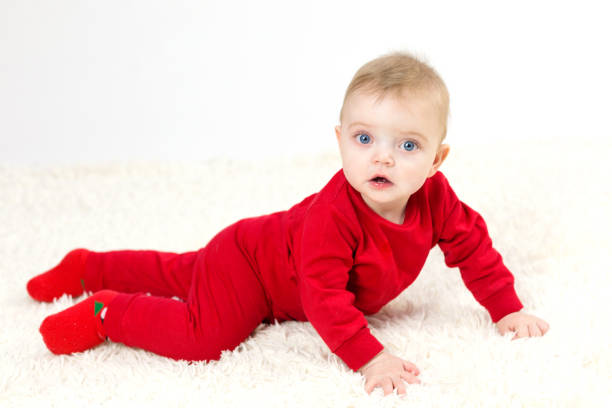 istock Small child in red clothes crawls on the floor 1299114988
