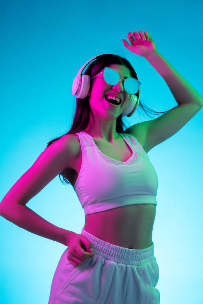 istock Brunette beautiful woman's portrait isolated on blue studio background in multicolored neon light 1299115094
