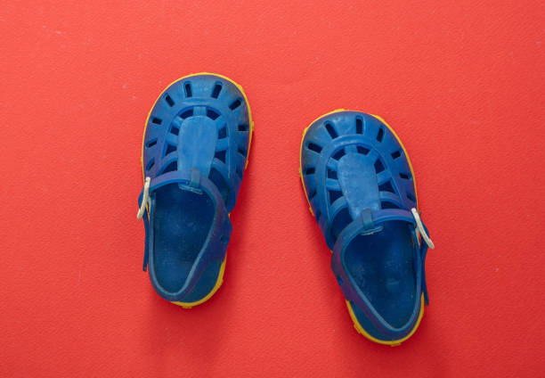 istock Baby blue sandals on orange red color background. 1299115232