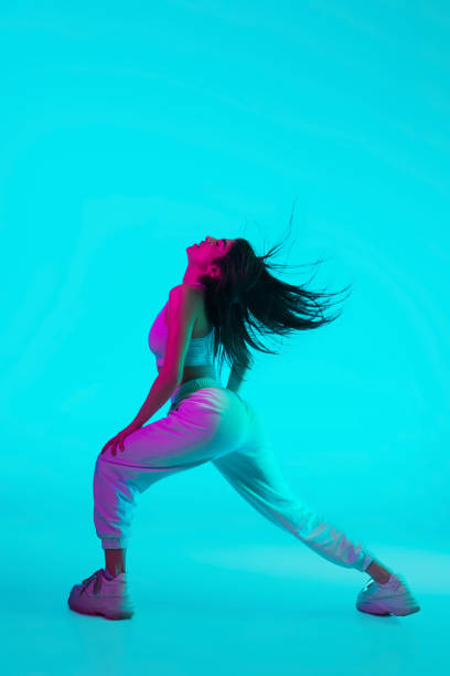 istock Brunette beautiful woman's portrait isolated on blue studio background in multicolored neon light 1299116145