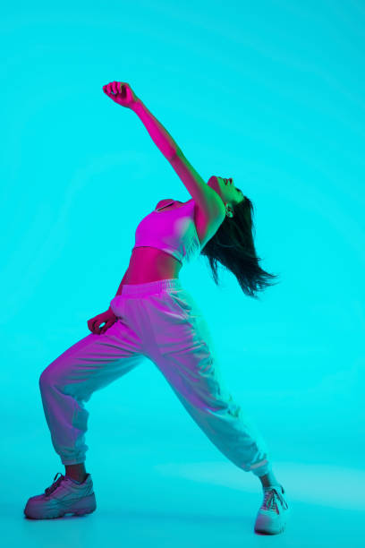 istock Brunette beautiful woman's portrait isolated on blue studio background in multicolored neon light 1299116149