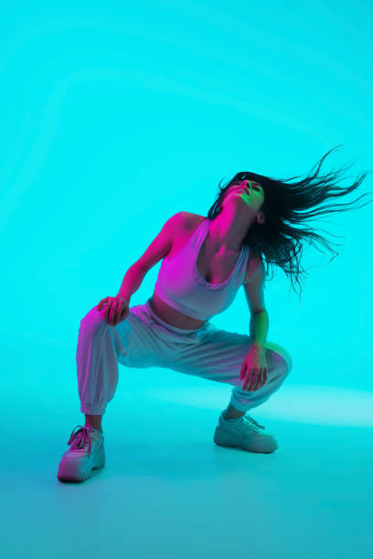 istock Brunette beautiful woman's portrait isolated on blue studio background in multicolored neon light 1299116150