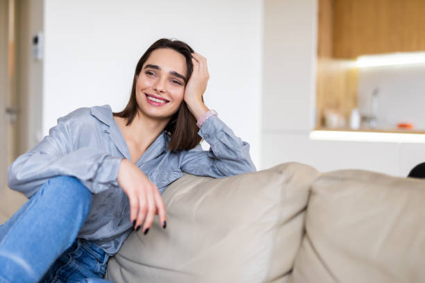 istock Young pretty woman resting on couch at home 1299116473
